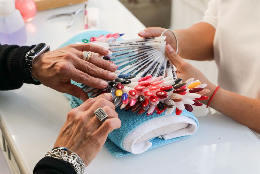 Client choosing from a wide selection of nail polish colours at a modern nail salon